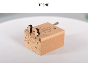 Macro detail of hand-cranked wooden music box with Love Songs engraving and animal face