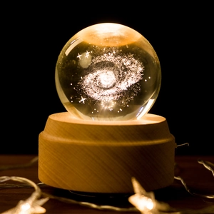 Luminous galaxy crystal ball night light on elegant beech wood base with warm LED glow