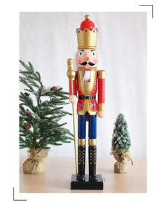 Detailansicht der hölzernen Nussknacker-Figur mit Goldkrone und blauen Schmuckelementen