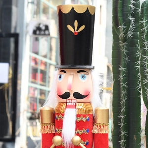 Detailansicht eines 90cm Nussknackers in roter Uniform mit goldenen Schulterstücken