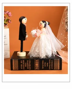 Detail of wooden wedding couple dolls featuring delicate lace dress and hand-painted suit