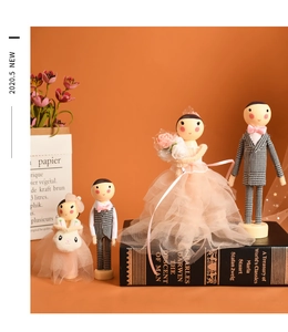 Close-up of wooden wedding doll set featuring tulle gowns and houndstooth suits