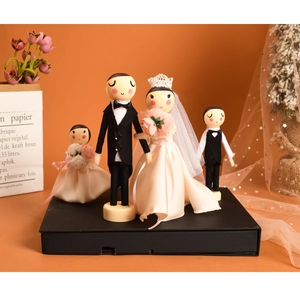 Detailed view of four handmade wooden wedding dolls with lace and satin fabric outfits