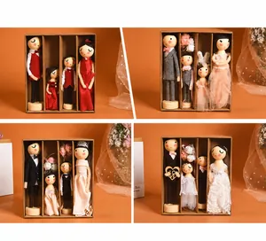 Miniature wooden peg dolls in craft window box with assorted wedding and family outfits