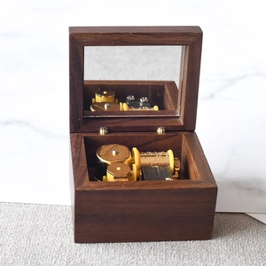 Handcrafted walnut wood music box with golden movement and internal mirror