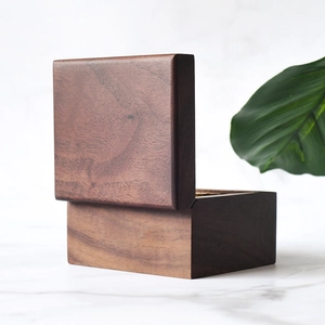 Handcrafted walnut wood music box with natural grain on a white marble background