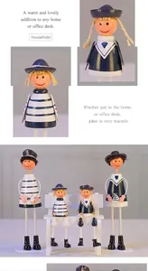 Detailed view of four nautical themed wooden dolls with hanging legs and anchor symbols