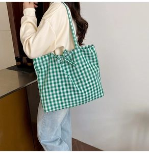 Close-up of green and white gingham tote bag with a decorative bow detail