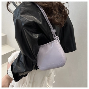 Close-up of lilac leather shoulder bag with knotted strap detail and embossed logo
