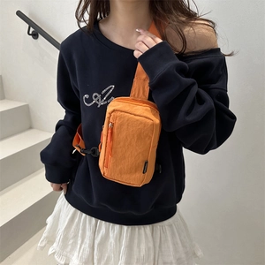 Bright orange nylon crossbody chest bag for outdoor sports shown on a person on stairs