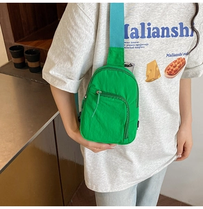 Close-up of lightweight neon green waterproof nylon chest bag with blue strap