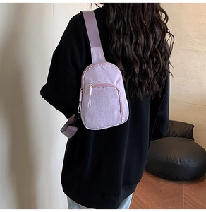 Detailed view of a mini purple nylon chest bag worn by a model in a casual setting