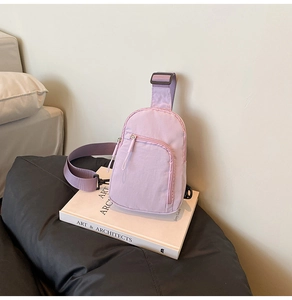 Close-up of lightweight light purple nylon chest bag on a book with zipper details