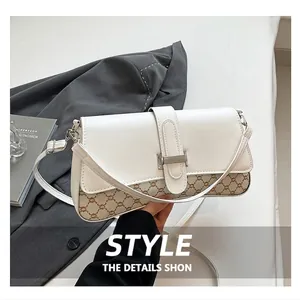 Detail of white leather shoulder bag with vintage monogram pattern and metal buckle