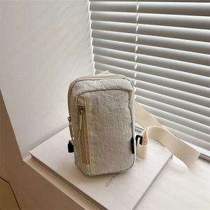 Minimalist ivory crossbody chest bag with adjustable strap and textured nylon fabric