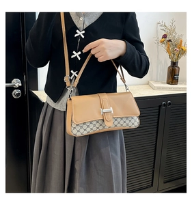 Detail of vintage flap bag with brown leather contrast and metallic H buckle clasp