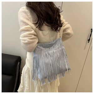 Λεπτομέρεια γαλάζιας τσάντας boho με κρόσσια, μεταλλικά καψούλια και μακριά φούντα
