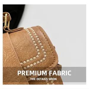Detailed view of the brown leather bag featuring star embroidery and gold hardware