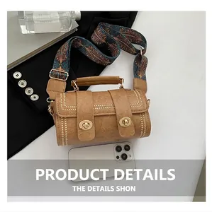 Close-up of retro brown barrel bag with double twist locks and colorful wide strap
