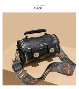 Detail of black leather handbag with golden lock and bohemian woven shoulder strap