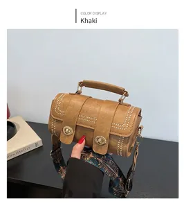 Detail of khaki Boston bag with gold rivets and bohemian patterned wide strap