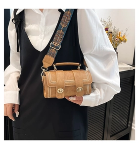 Detail of caramel square bag featuring white bead accents and ethnic patterned strap