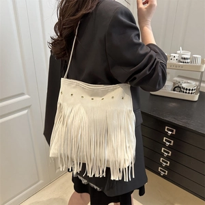 Off-white bohemian tassel shoulder bag with metallic grommets and long fringe detailing