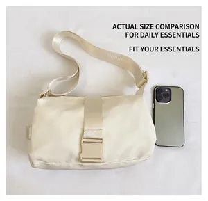 Size comparison of a cream nylon crossbody bag next to a smartphone with side handle details