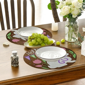 Macro view of round linen placemats with vintage rabbit and tulip Easter design