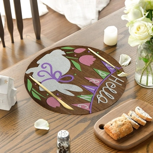 Close-up of a round linen placemat with an Easter bunny and tulip pattern design