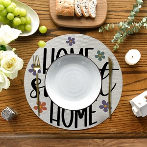 Macro detail of round linen placemat with floral print on dark wood dining table