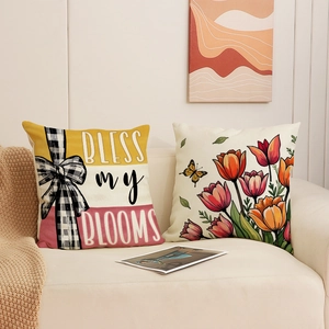 Set of two decorative tulip flower cushion covers with Bless My Blooms text on a sofa