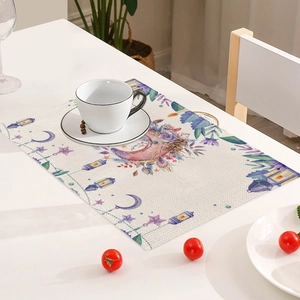 Close-up of linen placemat with watercolor moon and lantern print on a white table
