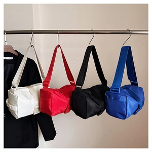 Minimalist nylon pillow bag collection showing four vibrant colors on metal hooks