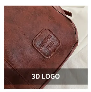 Detailed close-up of embossed logo on dark brown leather tote with vintage texture