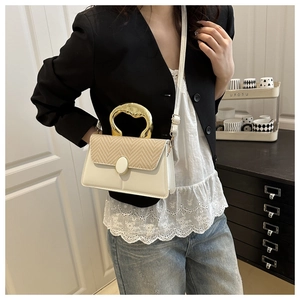 Detail of white leather and woven straw crossbody bag with elegant gold metal handle