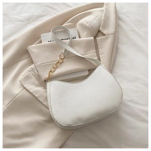 Detail of off-white hobo bag featuring a stylish gold chain strap and soft leather texture
