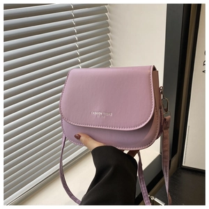 Detail of light purple saddle bag featuring Fashion Trend lettering and smooth PU texture