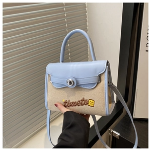 Dettaglio della borsa in pelle blu e tessuto intrecciato con ricami e chiusura in argento