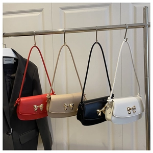 Détail de sacs bandoulière multicolores avec fermoirs nœud en métal sur un présentoir