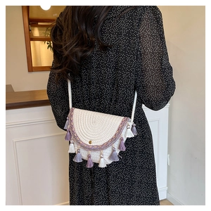 Detail of bohemian semi-circle woven bag with ethnic purple tassels and fringe on model