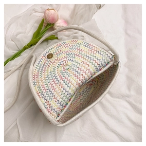 Détail du sac demi-lune tissé à la main avec coutures arc-en-ciel et bandoulière en chanvre