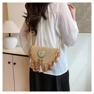 Detail of bohemian woven straw bag featuring colorful fringe and sunburst bead pattern