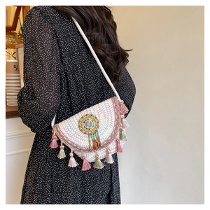 Détail d'un sac besace bohème coloré avec pompons et motifs perlés décoratifs