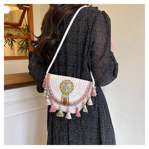 Detail of bohemian woven saddle bag with colorful wave embroidery and festive tassels