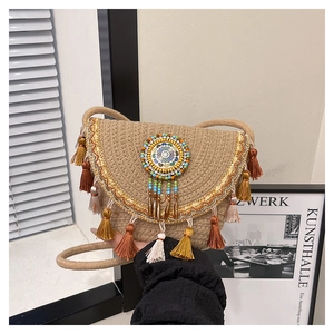 Détail du sac de selle en paille tressée avec franges colorées et ornement ethnique