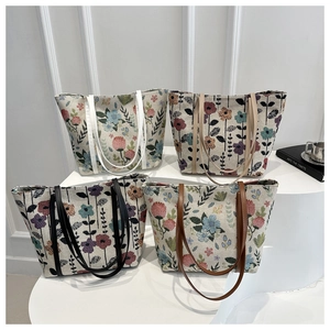 Vue détaillée de quatre cabas en toile à fleurs vintage sur des socles blancs
