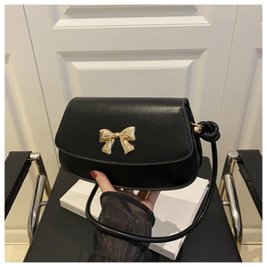 Gros plan du sac à bandoulière en cuir PU noir avec un fermoir doré en nœud