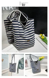 Detailed close-up of navy blue striped canvas tote bag with woven rope handles and leather patch