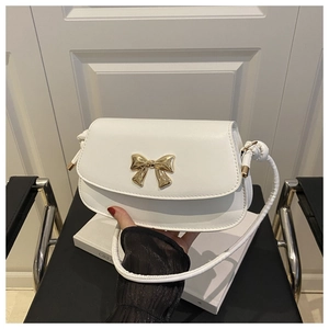 Détail du sac bandoulière blanc en PU avec boucle nœud doré et bandoulière en corde